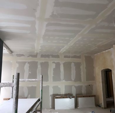 Rohbau mit verspachtelten Wänden und Decke, unvollendete Bauarbeiten sichtbar.